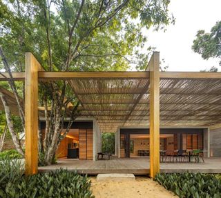 sand house by studiomk27, showing timber and bamboo house in tropical setting surrounding by bahia flora