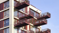 the Brentford Project showing red metal balconies jutting into the air against blue skies