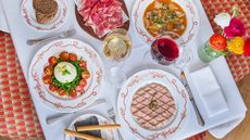 Array of dishes and wine on table at Cantinetta Antinori restaurant, London